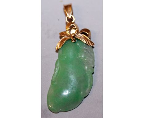 A CHINESE CARVED JADE AND GOLD PENDANT.