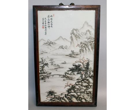 A CHINESE HARDWOOD FRAMED PORCELAIN PANEL, decorated with calligraphy and with a river landscape scene, the frame 23in x 14.2