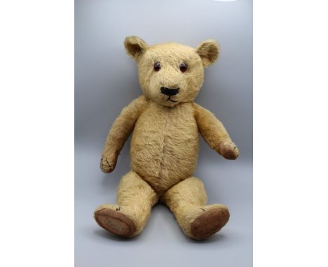 A mid 20th century Chad Valley growling blonde mohair teddy bear with glass eyes, stitched nose and claws, original pads and 