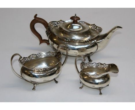 A three piece silver bachelors teaset in George III taste with pierced decoration comprising a teapot, milk jug, sugar basin,