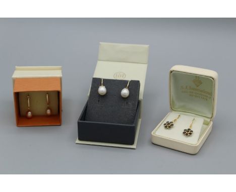A pair of plated 18carat gold earring set with sapphires, a pair of orangey/pink cultured pearl earrings in a yellow metal se