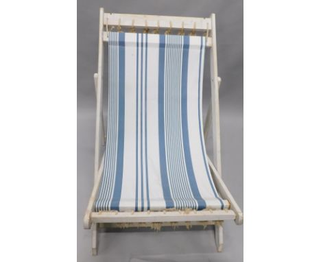 A vintage style cream painted deck chair, with striped linen type fabric and rope tassels 