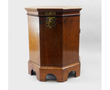 An early 19thC oak coal box, with an octagonal top, hinged to enclose a vacant interior with decorative brass escutcheon, on 