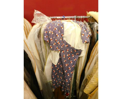 A quantity of ladies' vintage clothing, to include a floral two piece top and skirt set, camel coloured cape, red felt jacket