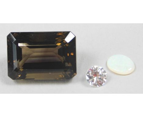 Three loose gemstones, to include a smokey quartz, opal double and an imitation diamond. 