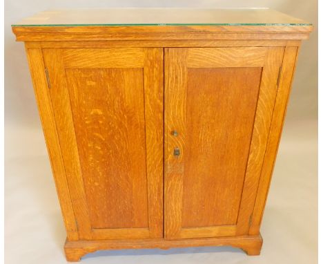 An oak side cabinet, with two panelled doors on bracket feet, 91cm wide