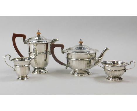 A George V silver four piece tea set, with tapering faceted sides, composition handle and knop to teapot and hot water jug, B