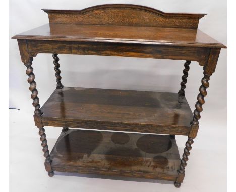 A oak buffet, the shaped back raised above three rectangular sections, broken by barley twist columns on compressed feet, 116
