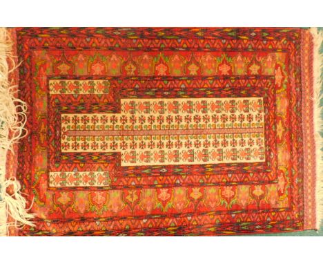 An Eastern patterned prayer rug, with an arrow design, on a red ground, 91cm x 125cm