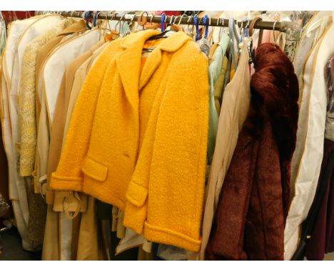A quantity of ladies' vintage clothing, to include macs, camel coloured coats, burgundy faux fur short length jacket etc. (on