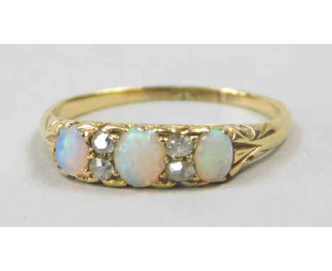 An 18ct gold opal and diamond dress ring, set with three opals and four tiny diamonds, 2.6g all in. 