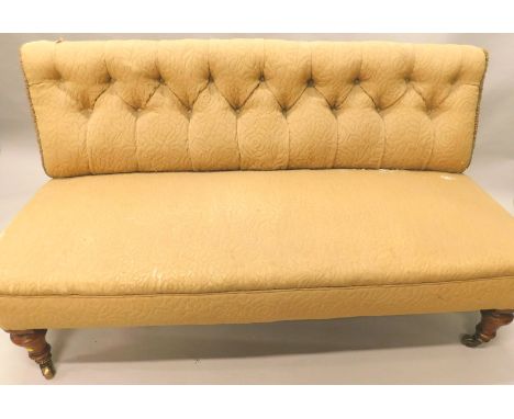 A Victorian mahogany sofa, with a button back, padded seat, on turned legs with castors, designed without arms