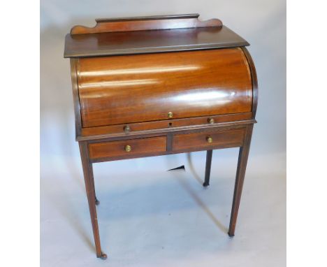 An Edwardian mahogany cylinder bureau, the top with a boxwood strung gallery and a moulded edge, above a fall front enclosing