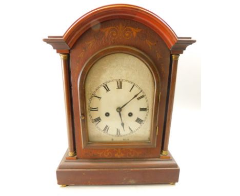 An early 20thC mantel clock, in a mahogany and marquetry case, the arched silver dial with Roman numerals, brass movement, 42