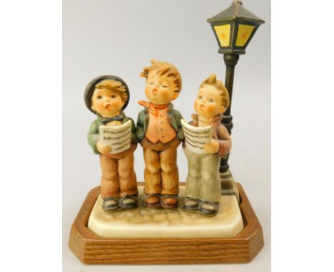 A Goebel Hummel figure group, a Tuneful Trio on an oak base