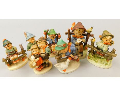 Seven Goebel Hummel figures, to include a boy seated with a flower, a boy with a goose, another on a fence etc.