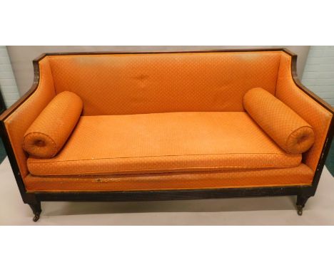 An early 19thC mahogany sofa, with a reeded frame, upholstered in patterned coral coloured fabric, on tapering legs with cera