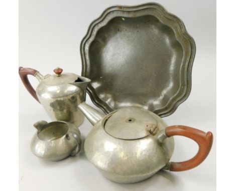 Four items of Tudric pewter, a teapot, milk jug, hot water jug and a plate with a shaped edge, (AF)