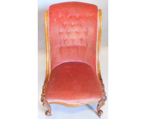 A Victorian walnut nursing chair, with a pink upholstered button back padded seat show frame on cabriole legs, with ceramic c