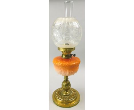 A Victorian brass oil lamp, the Art Nouveau style coral coloured glass reservoir moulded with flowers etc., the shade with st