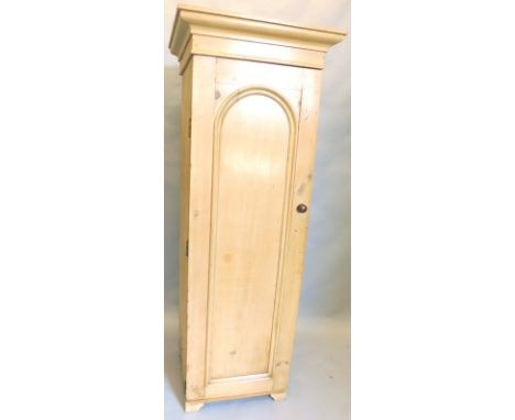 A pine pedestal wardrobe, with a moulded corner above a single panel door on bracket feet, 177cm high x 65cm wide