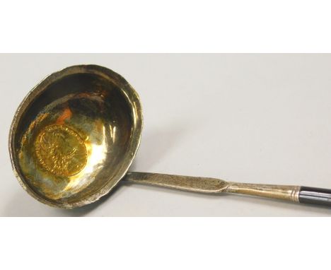 A 19thC white metal and twisted whale bone ladle, the bowl inset with an 18thC George III coin, later gilded