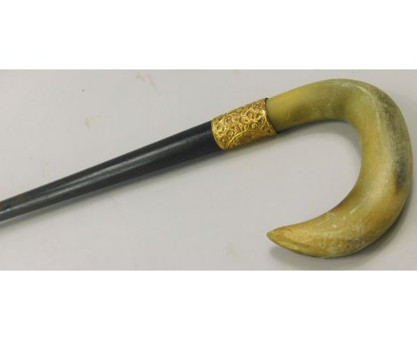 An early 20thC ebonised walking stick, with horn handle and yellow metal collar stamped 18ct, inscription relating to a Charl