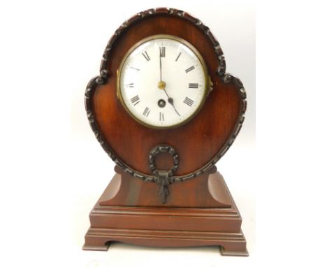 A late 19th/early 20thC mahogany balloon shaped mantel clock, the enamel dial with Roman numerals, the case carved with swags