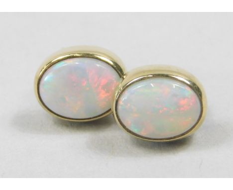 A pair of 9ct gold opal earrings, in oval stud form, with butterfly backs, boxed, 2g all in. 