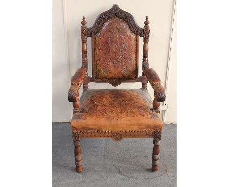 A 19th century heavily carved oak armchair in tooled leather (finial missing)  
