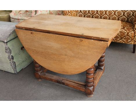 An antique oak gate leg table fitted a drawer 