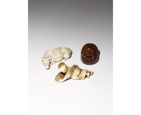 λ TWO JAPANESE IVORY CARVINGS EDO AND MEIJI PERIOD, 19TH CENTURY One a netsuke carved as a recumbent ox, resting with its hea