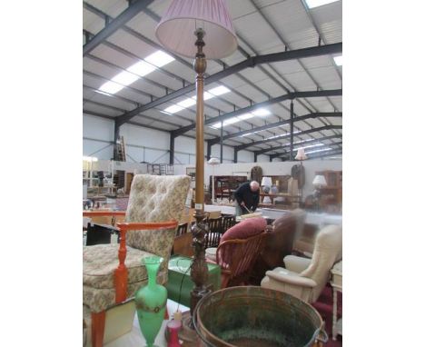 A carved wood standard lamp with shade