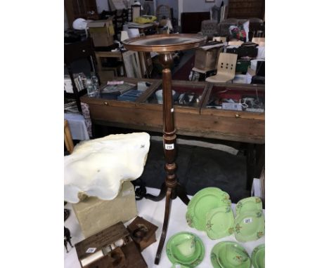 A dark wood stained tripod torchiere stand