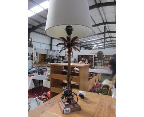 A table lamp in the shape of a palm tree complete with shade