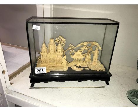 A cork model of temples & trees in glass cabinet