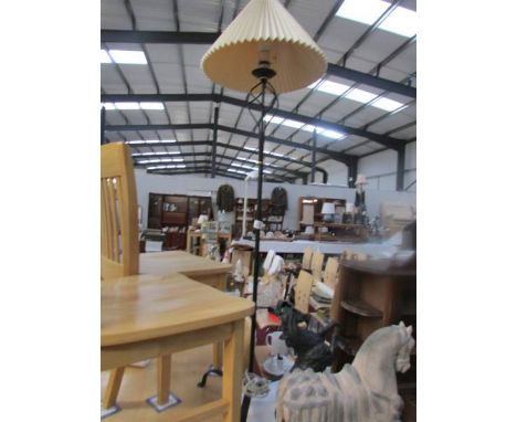 A wrought iron standard lamp with shade