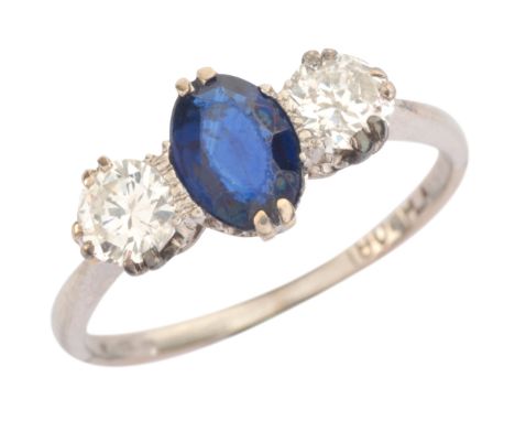 A SAPPHIRE AND DIAMOND THREE STONE RINGin 18ct white gold and platinum, set with an oval cut sapphire of c.0.70 carats, flank