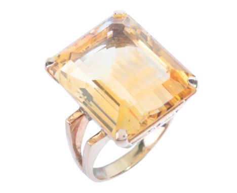 A VINTAGE CITRINE COCKTAIL RINGin 18ct gold, set with a step cut citrine of c.24.70 carats, to stylised shoulders, stamped '7