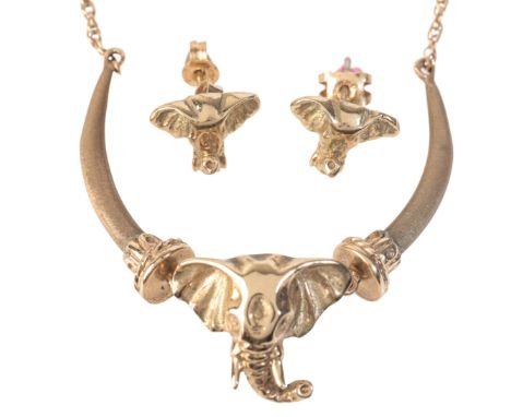 AN ELEPHANT NECKLACEin 9ct gold, comprising a pendant designed as tusks articulated to an elephant's head, suspended from a t