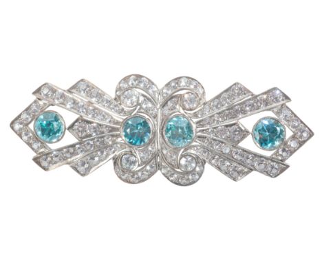 AN ZIRCON AND PASTE BROOCHin sterling silver, set with four round cut blue zircons and paste stones over a stylised design, s