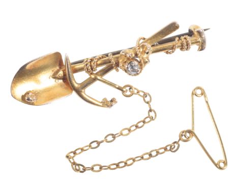 A VINTAGE GOLD RUSH BROOCHin 18ct gold, comprising a spade and pick axe entangled in rope, set with an old mine cut diamond o