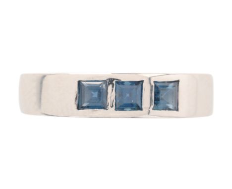 A SAPPHIRE RINGin platinum, set with three step cut sapphires held in rubover settings, obscured assay marks, size I1/2 48, (