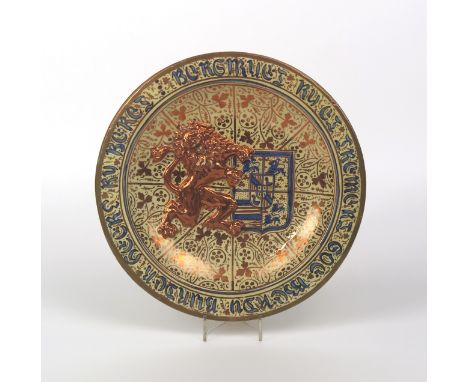 A large Hispano-Moresque charger, 19th century, moulded in high relief with a lion rampant holding a shield bearing a quarter