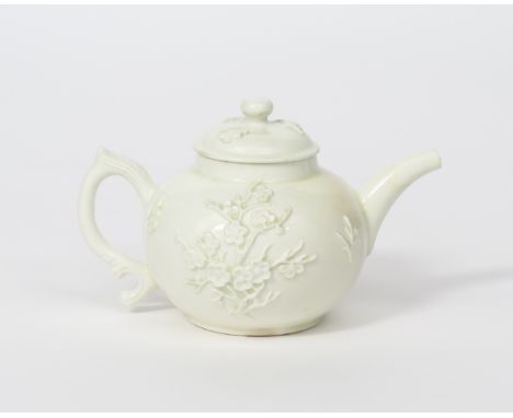 An early Bow white-glazed teapot and cover, c.1753-55, the squat globular form crisply applied with sprays of flowering prunu