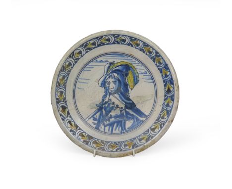 A Delft portrait dish, probably 19th century, painted with the portrait of a Dutch gentleman wearing a plumed hat, the rim wi