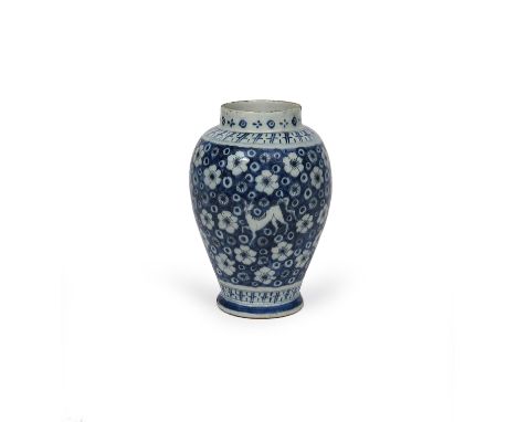 A Delft vase, c.1700, after a Chinese Kangxi original, painted in blue with an allover design of mythical animals on a prunus