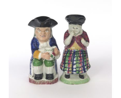 A Davenport Toby jug, 1st half 19th century, seated with a boldly patterned jug of ale, raised on a base sponged with green a