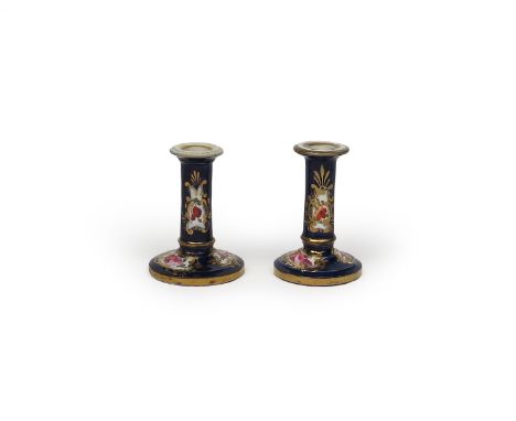 A pair of Spode miniature candlesticks, c.1820, of cylindrical form issuing from circular bases, painted with panels of flowe