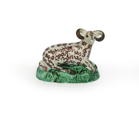 A large Staffordshire pearlware figure of a ram, c.1790-1800, recumbent on a domed grassy base, his head turned to the right,
